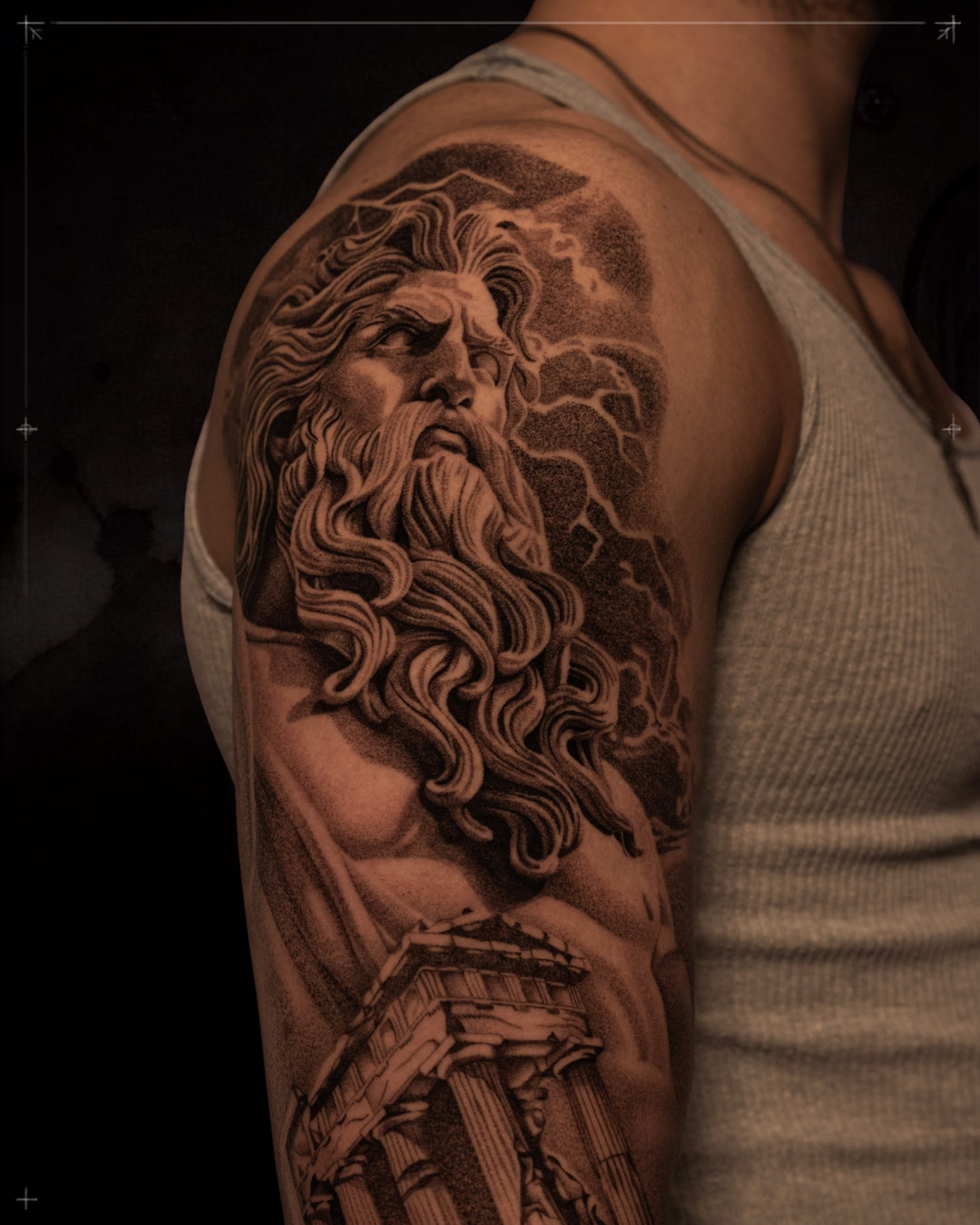 Black and grey realism tattoo by Jon LaFlore, Dallas TX — Zeus classical sculpture shoulder sleeve with dramatic chiaroscuro shading